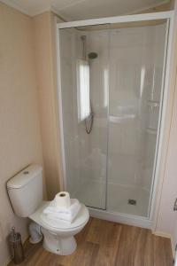 Un baño con inodoro y ducha de cristal. en Rowan Lodge with Hot Tub, en Malton 10 fotos más