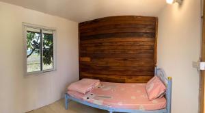 ein Bett in einem Zimmer mit einer Holzwand in der Unterkunft Khunkorn Fishing Farm Stay in Ban Mae Kon + 8 Fotos
