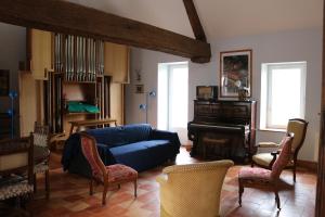 sala de estar con sofá azul y piano en Chez Célestine, en Souvigny