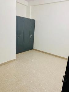 斋浦尔JSR Boys Hostel - Pratap Nagar的一间空房间,房间里有一扇蓝色的门