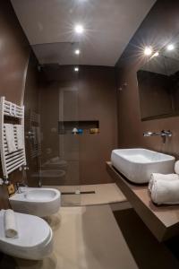 a bathroom with two toilets and a tub and a sink at B&B Murex in Bari