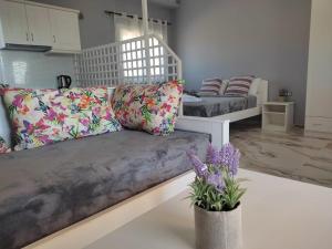 ein Wohnzimmer mit einer Couch und Blumen in der Unterkunft Pefkari Bay Villas in Pefkari