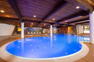 a large swimming pool with a large blue pool at Hotel Slovan in Vysoke Tatry - Tatranska Lomnica.