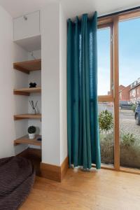 Habitación con una ventana con cortinas verdes en The Old Cooperage by Staytor Accommodation, en Exeter