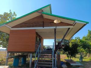 ein kleiner Schuppen mit einer Treppe, die hinaufführt in der Unterkunft Khunkorn Fishing Farm Stay in Ban Mae Kon