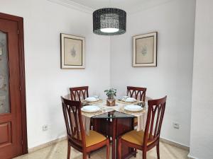 a dining room with a table and four chairs at Céntrico Apartamento Jardines de Vallellano in Córdoba