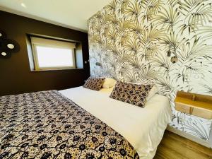 a bedroom with a large bed with a wall at Hôtel Le Troubadour à Rocamadour in Rocamadour