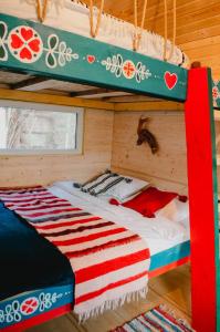 Bett in einem Holzzimmer mit Etagenbett in der Unterkunft Fain in Lunca Bradului