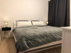 una camera da letto con un letto con due lampade sopra di Modernes 2,5 Zimmer Apartment in Eppelborn, privater Eingang, eigener Parkplatz und Terrasse, Deine Ferienwohnung in Eppelborn mitten im Herzen des Saarlandes a Eppelborn