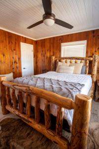 a bedroom with a bed made out of logs at Nebo's Foot, Cabin Escape with Game-Barn in Dardanelle