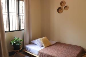 a small bedroom with a bed and a window at Charming 2-Bed House in Kampala in Kampala