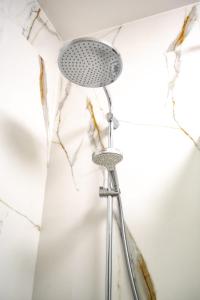 a shower head in a bathroom with a wall at Porto in Gdańsk