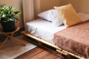 a bed on a pallet with a plant next to it at Charming 2-Bed House in Kampala in Kampala