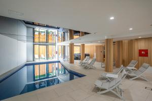 a swimming pool in a building with chairs around it at Hotel Palcich Plitvice in Čatrnja