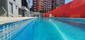 a large swimming pool in a city with buildings at Studio Gurruchaga Vip in Buenos Aires