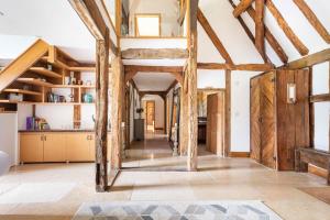 kuchnia z drewnianymi belkami stropowymi i długim korytarzem w obiekcie Period Luxury Converted Barn Windsor/Maidenhead - Perfect for family groups w mieście Taplow