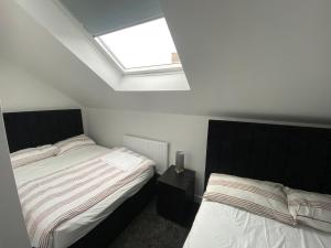 a bedroom with two beds and a skylight at Modern holiday home in Greetland