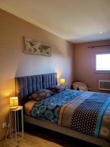 Méjannes-le-ClapにあるChambres d'hôte ROUQUARTのベッドルーム1室(青いタフトのヘッドボード付きのベッド1台付)