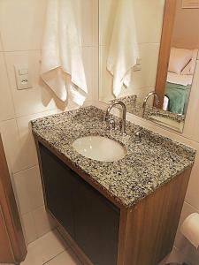 a bathroom with a sink and a mirror at Studio Moderno e Aconchegante in Curitiba