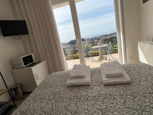 a bedroom with a bed and a large window at Alfazema Sunset House in Vila Nova de Gaia