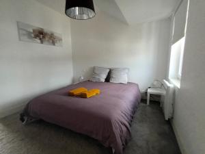 1 dormitorio con 1 cama con 2 toallas amarillas en petit Gîte T2 des balcons d'Ancenis, en Ancenis