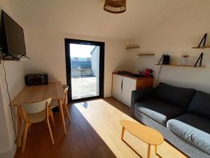 een woonkamer met een bank en een tafel bij petit Gîte T2 des balcons d'Ancenis in Ancenis