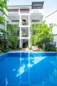 a hotel with a swimming pool in front of a building at My Anh Boutique Villa Hoi An in Hoi An