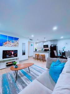 Modern Santorini Suite Houston NRG TMC Luxurious Walkable في هيوستن: غرفة معيشة مع أريكة بيضاء وطاولة