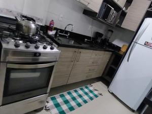 uma cozinha com um fogão e um frigorífico em Espaçoso aconchegante em Capão da Canoa