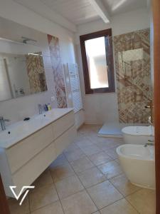 a bathroom with a tub and a sink and a toilet at Villa Tico in Custonaci
