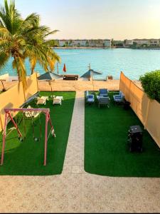 a backyard with a playground with a swing at درة العروس فيلا البيلسان الشاطي الازرق in Durat Alarous
