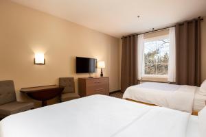 een hotelkamer met 2 bedden en een raam bij Holiday Inn Express & Suites Tremblant, an IHG Hotel in Mont-Tremblant