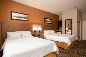 a hotel room with two beds with white sheets at Holiday Inn Express & Suites Tremblant, an IHG Hotel in Mont-Tremblant