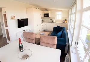 a living room with a couch and a table with a bottle of wine at Strandbungalow Jette in Glowe