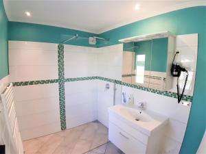 a bathroom with a white sink and a shower at Strandbungalow Jette in Glowe