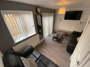 a living room with a couch and a table at Modern holiday home in Greetland