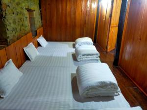 a group of four beds in a room at Minh Khang Homestay - Làng đá cổ Khuổi Ky in Cao Bằng