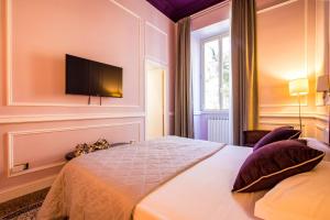 a bedroom with a bed with a television on the wall at Hold Rome - Luxury Suites in Rome