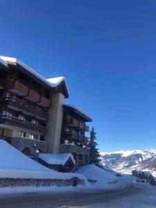 duży budynek z śniegiem przed nim w obiekcie Studio 4 personnes proche des pistes w mieście La Plagne Tarentaise +6 zdjęć