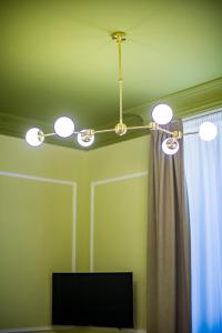 una lámpara de araña en una habitación con cortina y TV en Hold Rome - Luxury Suites, en Roma