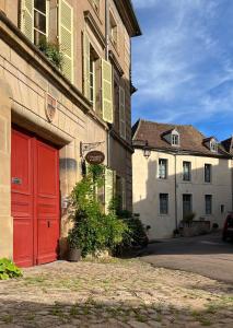 una puerta roja en el lateral de un edificio en Maison Sainte Barbe, en Autun
