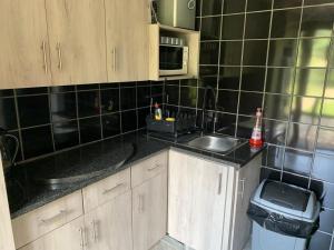 a kitchen with a sink and a microwave at Mabalingwe Elephant Lodge 256A in Moheme