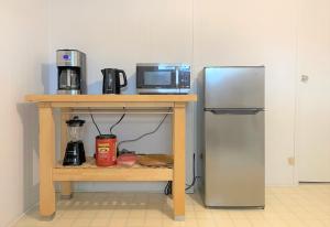 a kitchen with a table with a microwave and a refrigerator at Montreal - Laval Haven - Entire rental unit in Laval