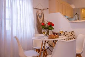een tafel met een vaas met bloemen en twee glazen wijn bij Hidden Serenity in Mykonos-stad