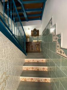 a staircase in a house with a blue railing at La carchata ático in Siete Aguas
