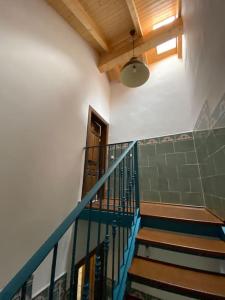 a staircase with a blue railing in a building at La carchata ático in Siete Aguas