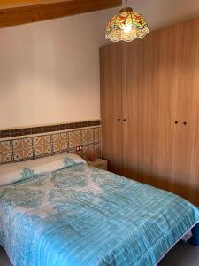 a bedroom with a bed and a chandelier at La carchata ático in Siete Aguas