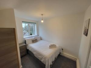 ein kleines Schlafzimmer mit einem Bett und einem Fenster in der Unterkunft Modern 3 bed Walking Distance to Wimbledon Tennis! in London