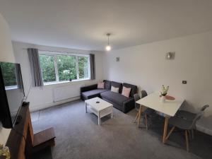 uma sala de estar com um sofá e uma mesa em Modern 3 bed Walking Distance to Wimbledon Tennis! em Londres