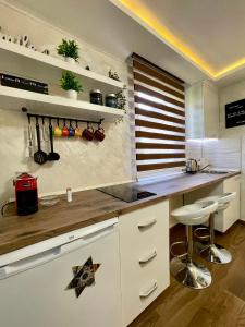 cocina con armarios blancos y encimera en Apartment Lena Niksic, en Nikšić